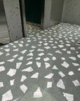 Integrated floor and wall decoration effect: a mixture of white natural marble aggregate and dark grey-green stone terrazzo tiles