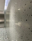 Integrated floor and wall decoration effect: a mixture of white natural marble aggregate and dark grey-green stone terrazzo tiles